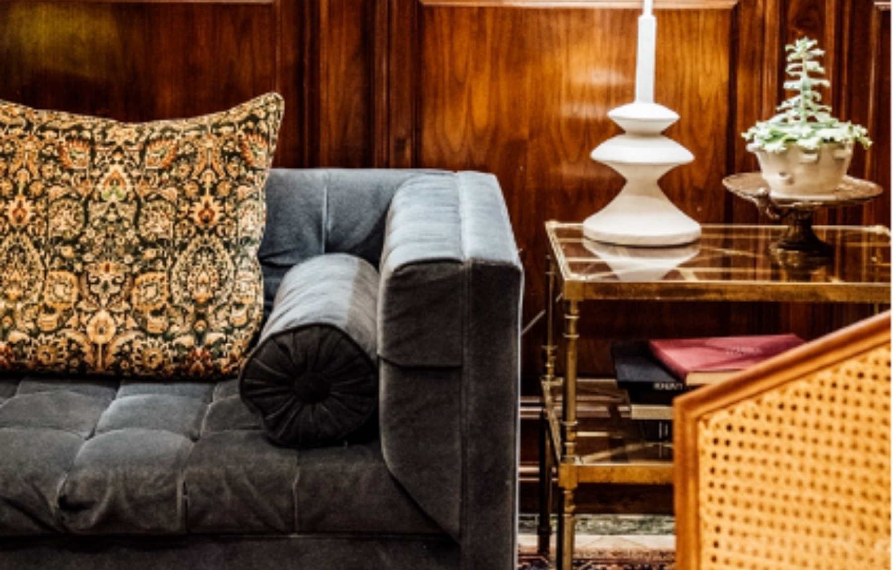 A seating area scene with a couch, side table, and a gallery wall of art on the wall behind