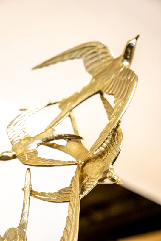 Metal gold birds flying around eachother